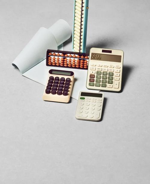 A mix of modern calculators and traditional abacuses on a gray surface, alongside rolled graph paper.
